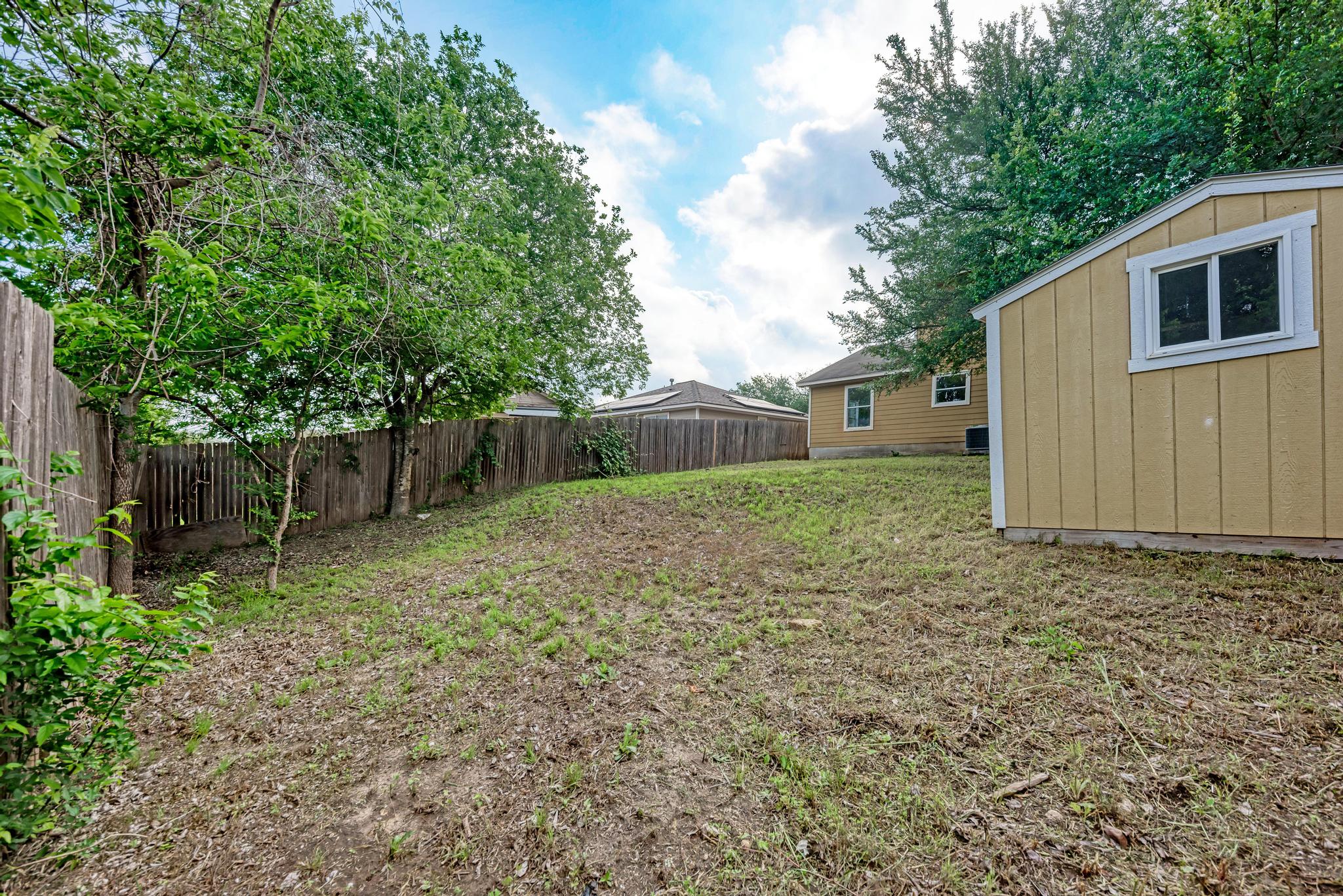 18108 Belfry Pass Manor, TX 78653 - Photo 36 of 40 a backyard of a house with lots of green space