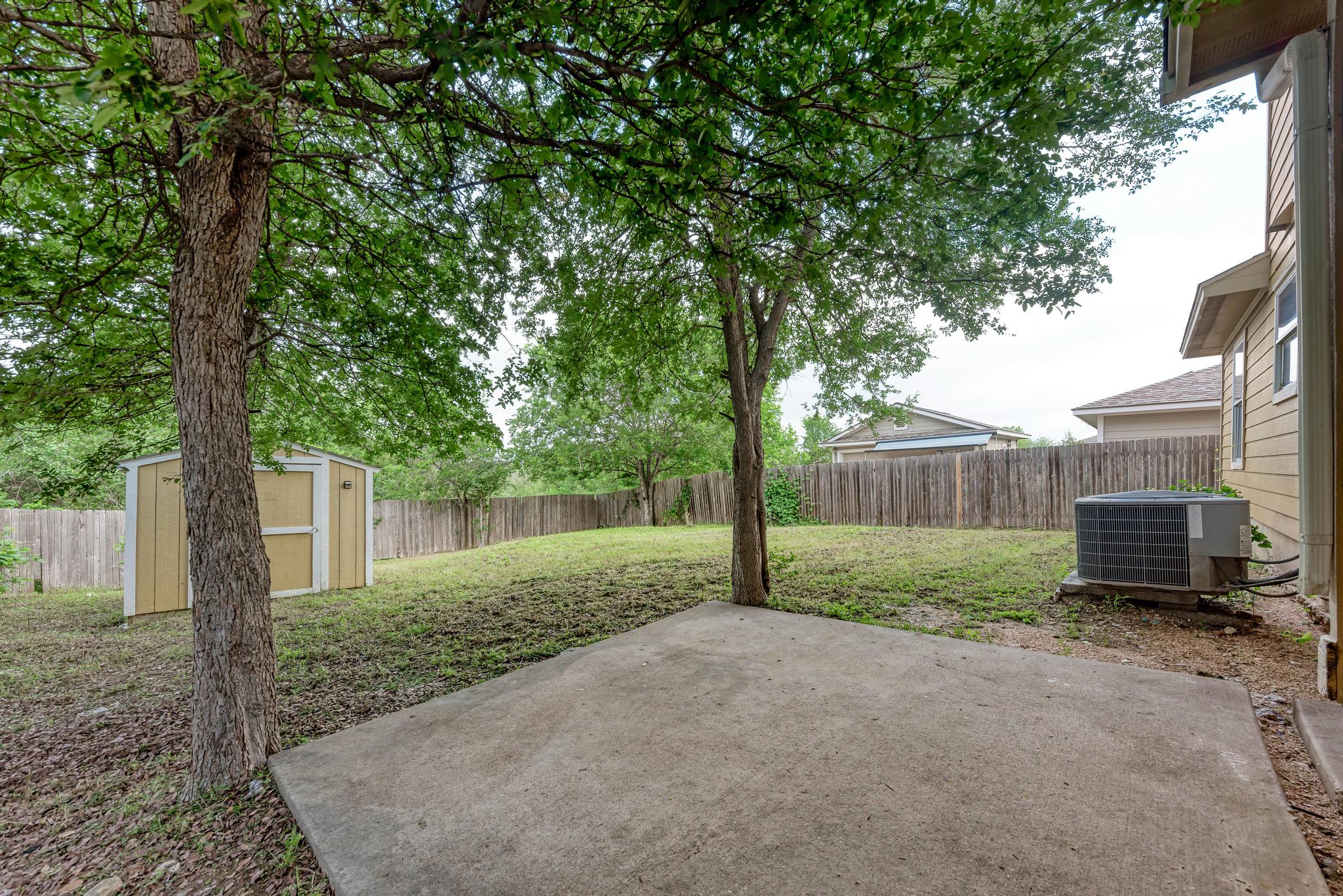 18108 Belfry Pass Manor, TX 78653 - Photo 5 of 40 a view of a backyard with large trees and a barn