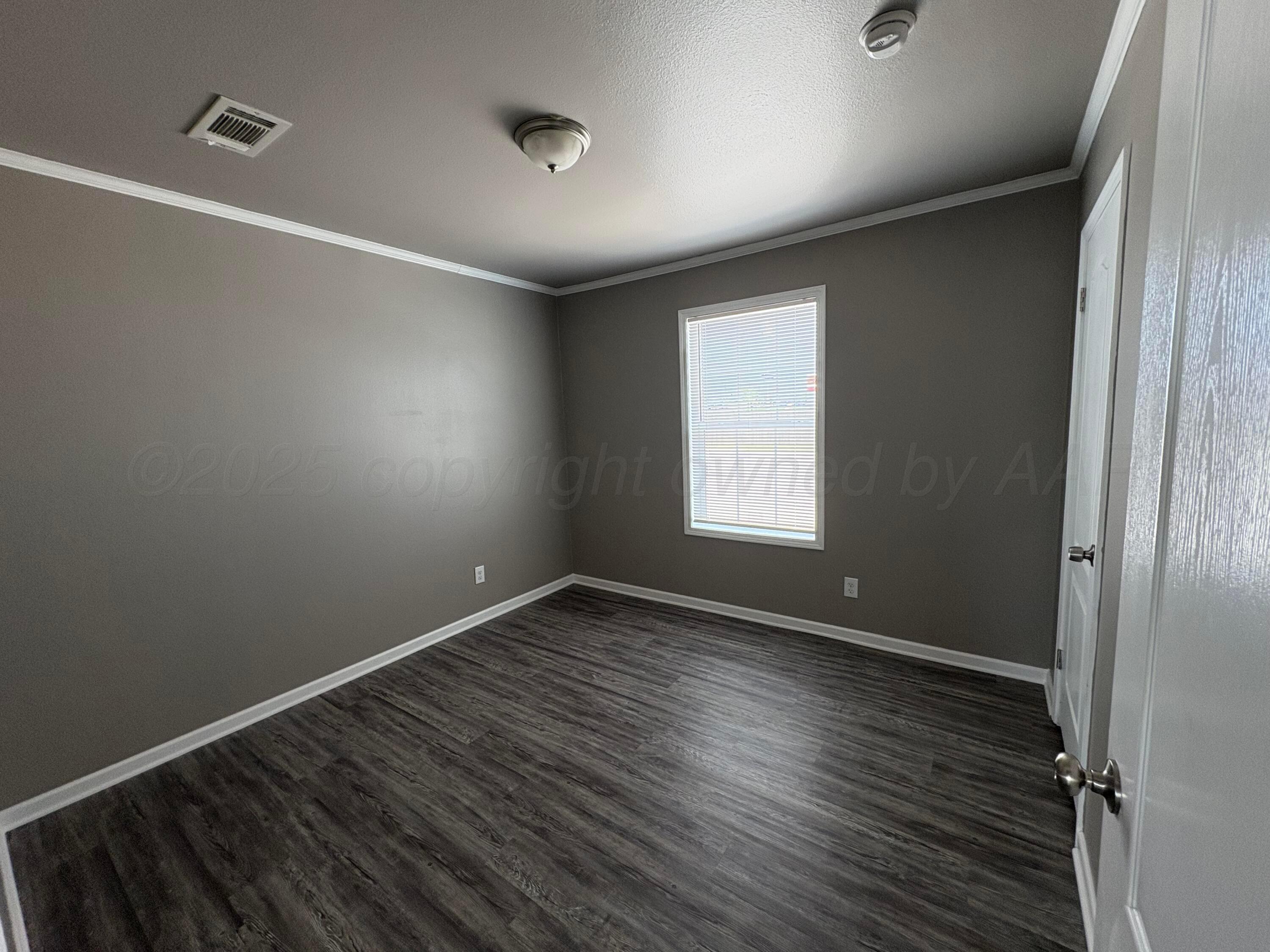 3501 Southeast 21st Avenue Amarillo, TX 79103 - Photo 7 of 11 an empty room with wooden floor and windows