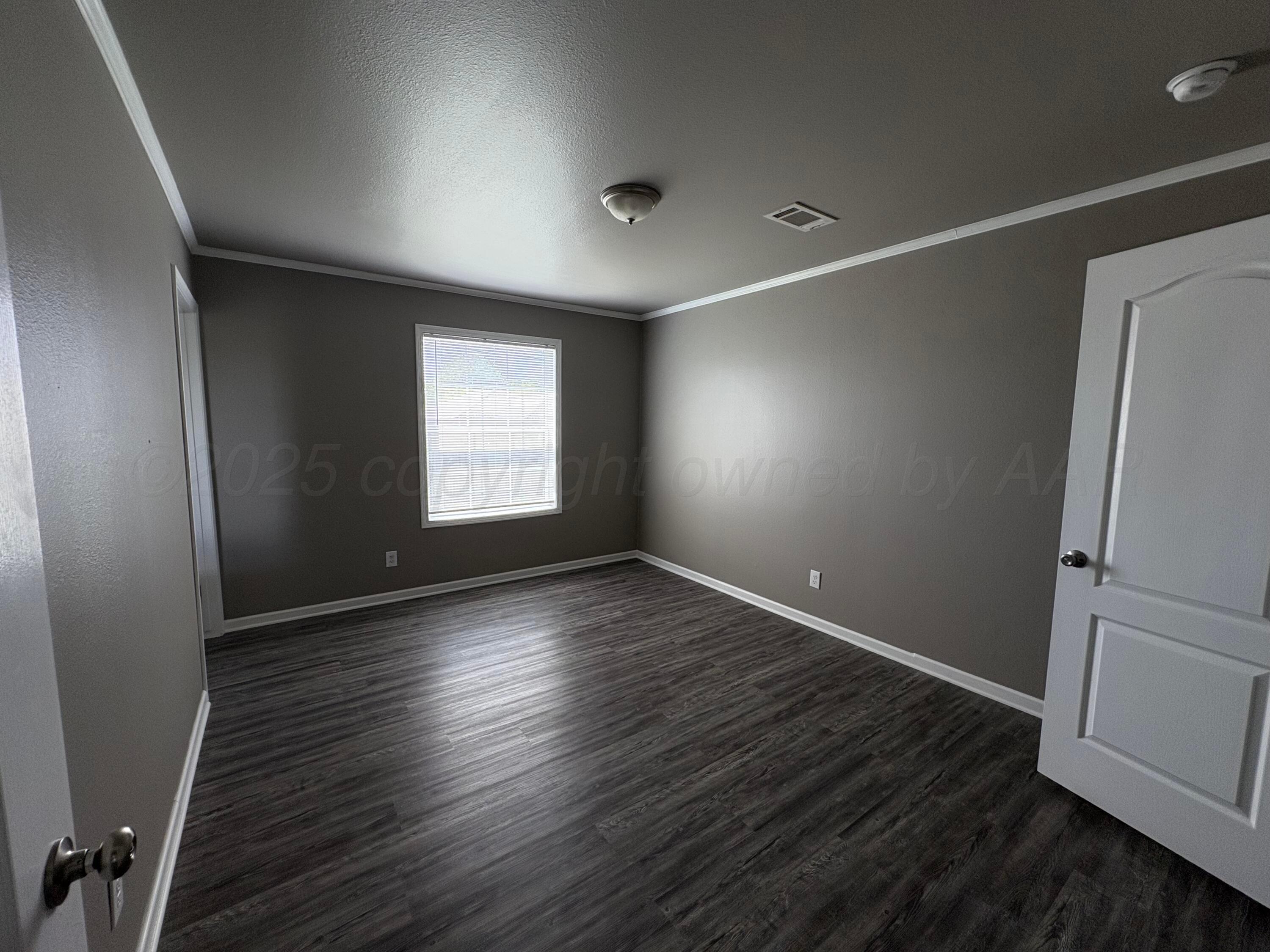 3501 Southeast 21st Avenue Amarillo, TX 79103 - Photo 8 of 11 an empty room with wooden floor and windows