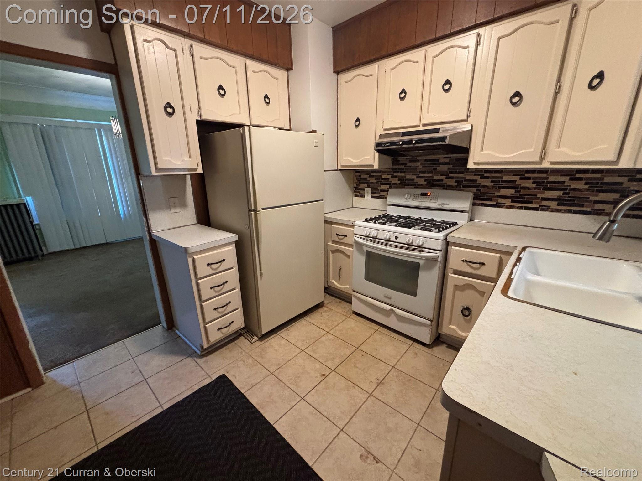 3237 Calvert Avenue Detroit, MI 48206 - Photo 7 of 8 Kitchen featuring extensive cabinetry, tile flooring, a gas range, and a double basin sink with a gooseneck faucet