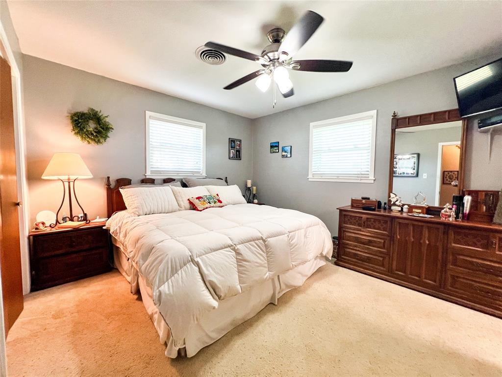 1009 North 7th Street Haskell, TX 79521 - Photo 16 of 26 a bedroom with a large bed and a chandelier