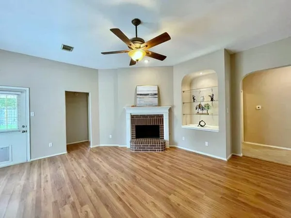 a view of an empty room with window and a fireplace