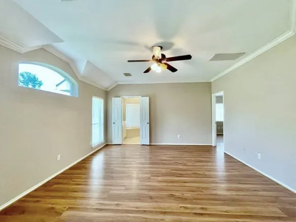 a view of an empty room with window and wooden floor