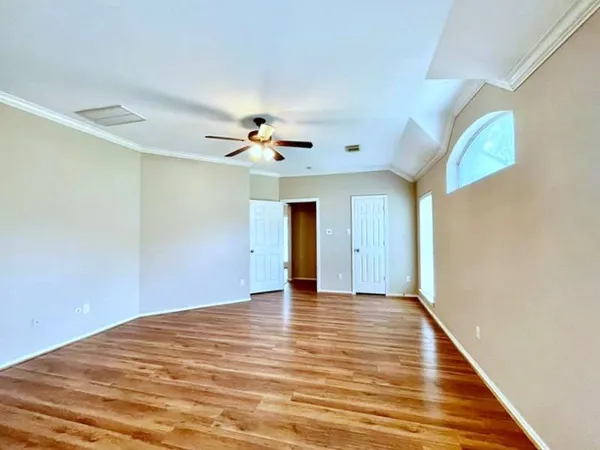 a view of an empty room with wooden floor