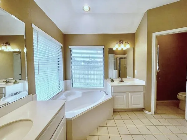 a bathroom with a granite countertop sink a toilet and bathtub