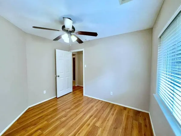 a view of empty room with wooden floor