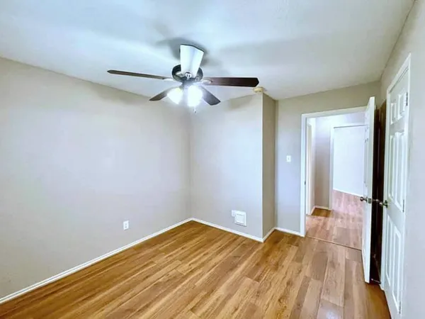 a view of a room with wooden floor and fan