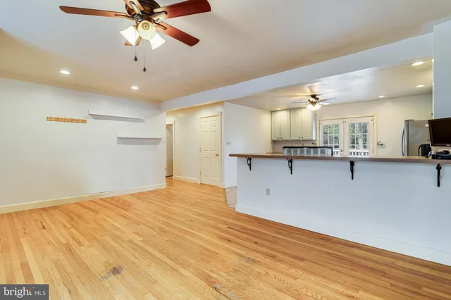 a view of an empty room and kitchen view