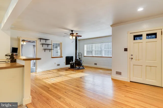 a view of a livingroom with wooden floor and furniture