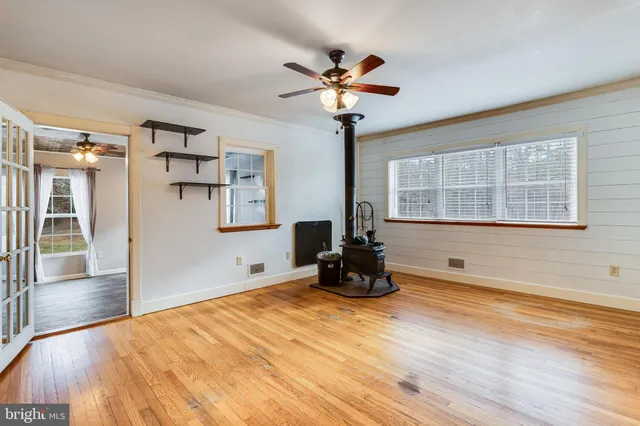 a view of a livingroom with wooden floor and a ceiling fan