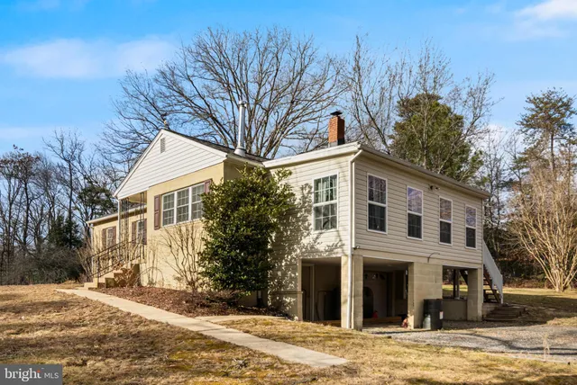 a front view of a house with a yard and trees