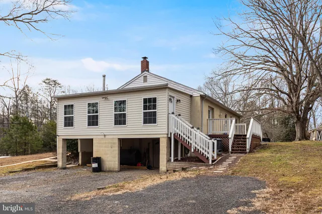 a view of a house with a yard and large trees