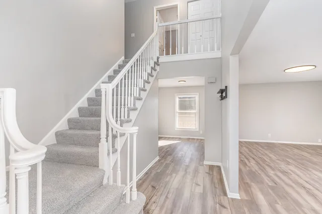 a view of entryway and hall with wooden floor