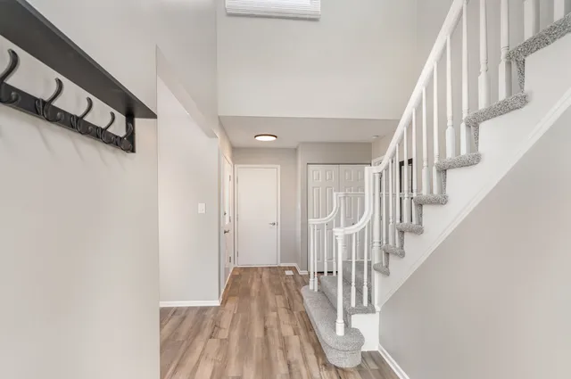 a view of staircase with wooden floor and white walls