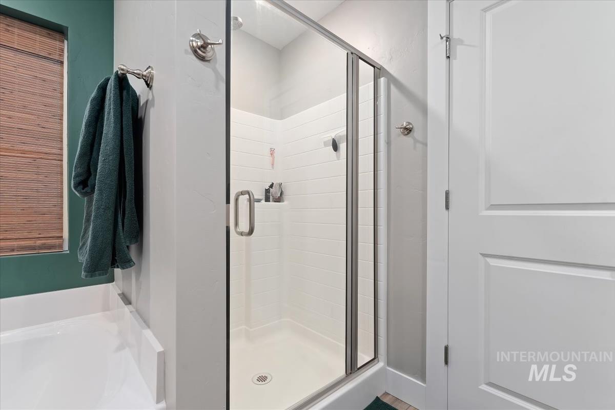 815 Knowledge Street Middleton, ID 83644 - Photo 30 of 49 Walk-in shower featuring a glass enclosure, white subway tile surround, and a rain showerhead