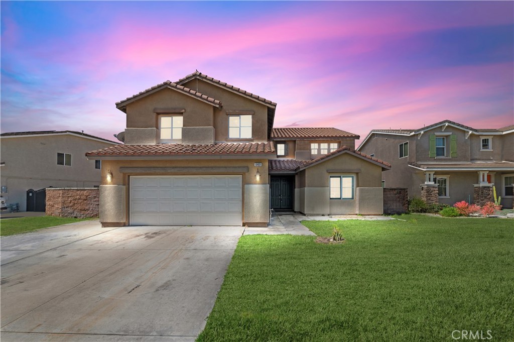 a front view of a house with a yard and garage
