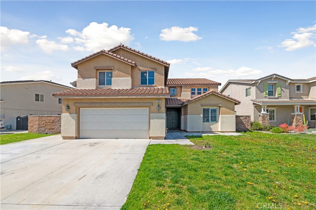 6469 Cattleman Drive Eastvale, CA 92880 - Photo 2 of 35 a front view of a house with a yard and garage