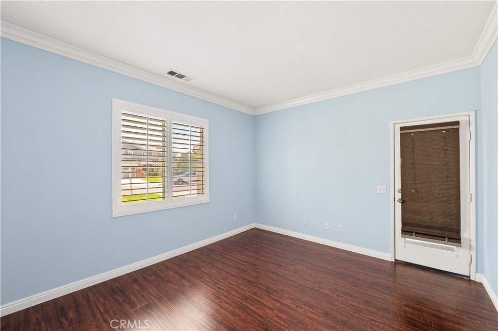 6469 Cattleman Drive Eastvale, CA 92880 - Photo 7 of 35 a view of an empty room with wooden floor and a window