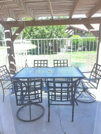 a view of a chairs and table in patio with a yard