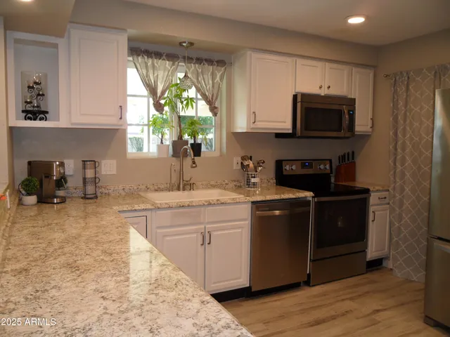 a view of a kitchen with dining area and chandelier
