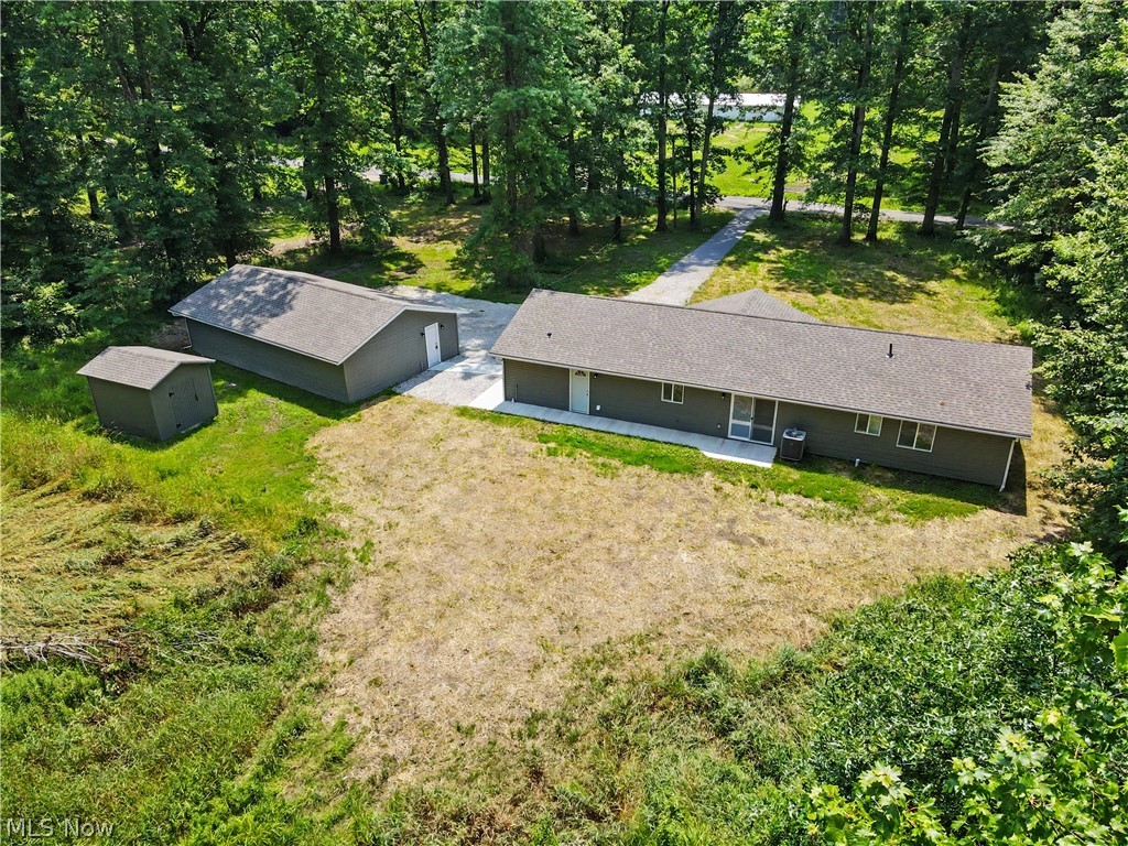 7583 Yale Road Atwater, OH 44201 - Photo 5 of 41 View of the backyard and back of the house and four car garage. 2026 Brand new roof, windows, man doors, storm doors, vinyl sliding, and so much more. Relax on the back concrete patio area.