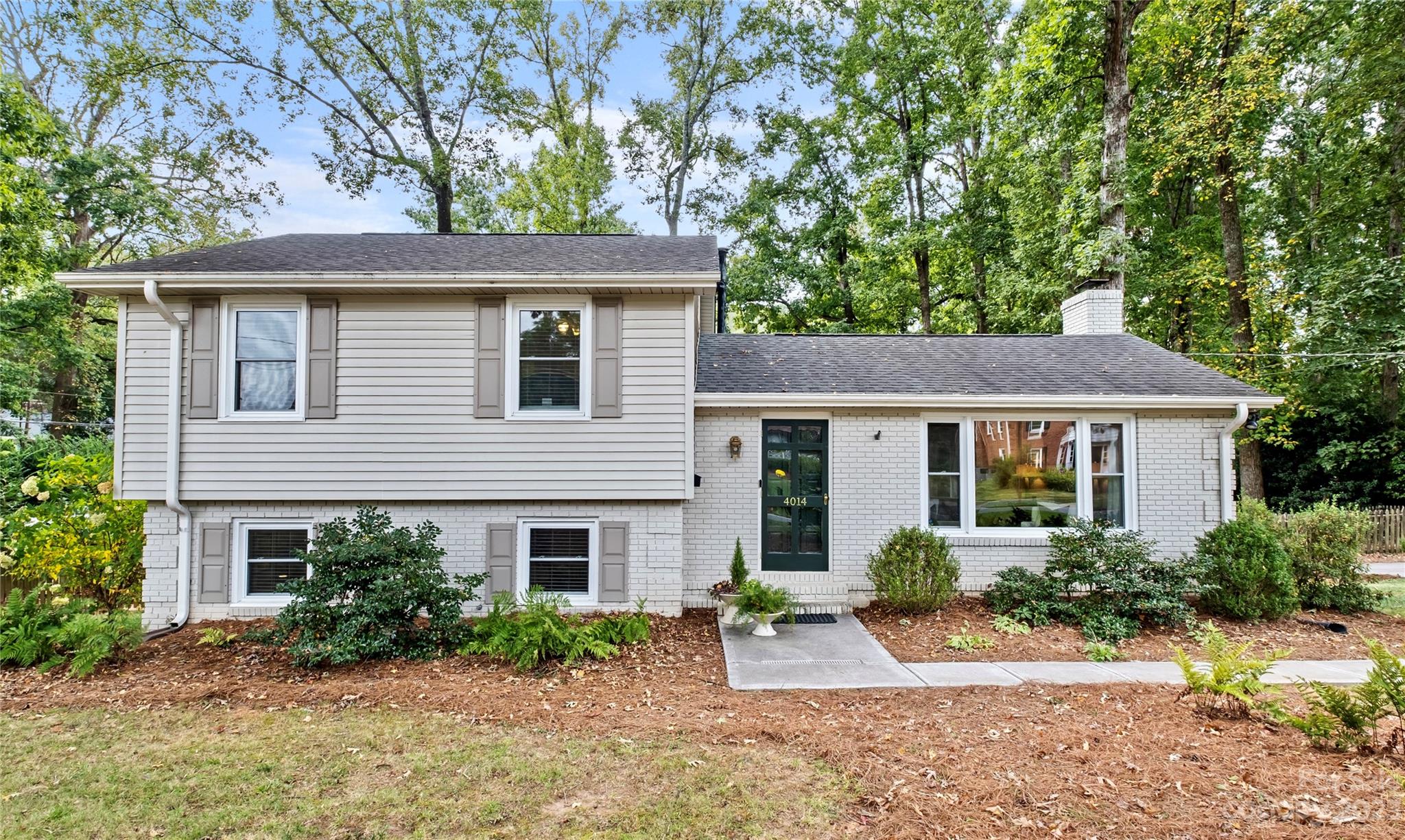 a front view of house with yard and trees around