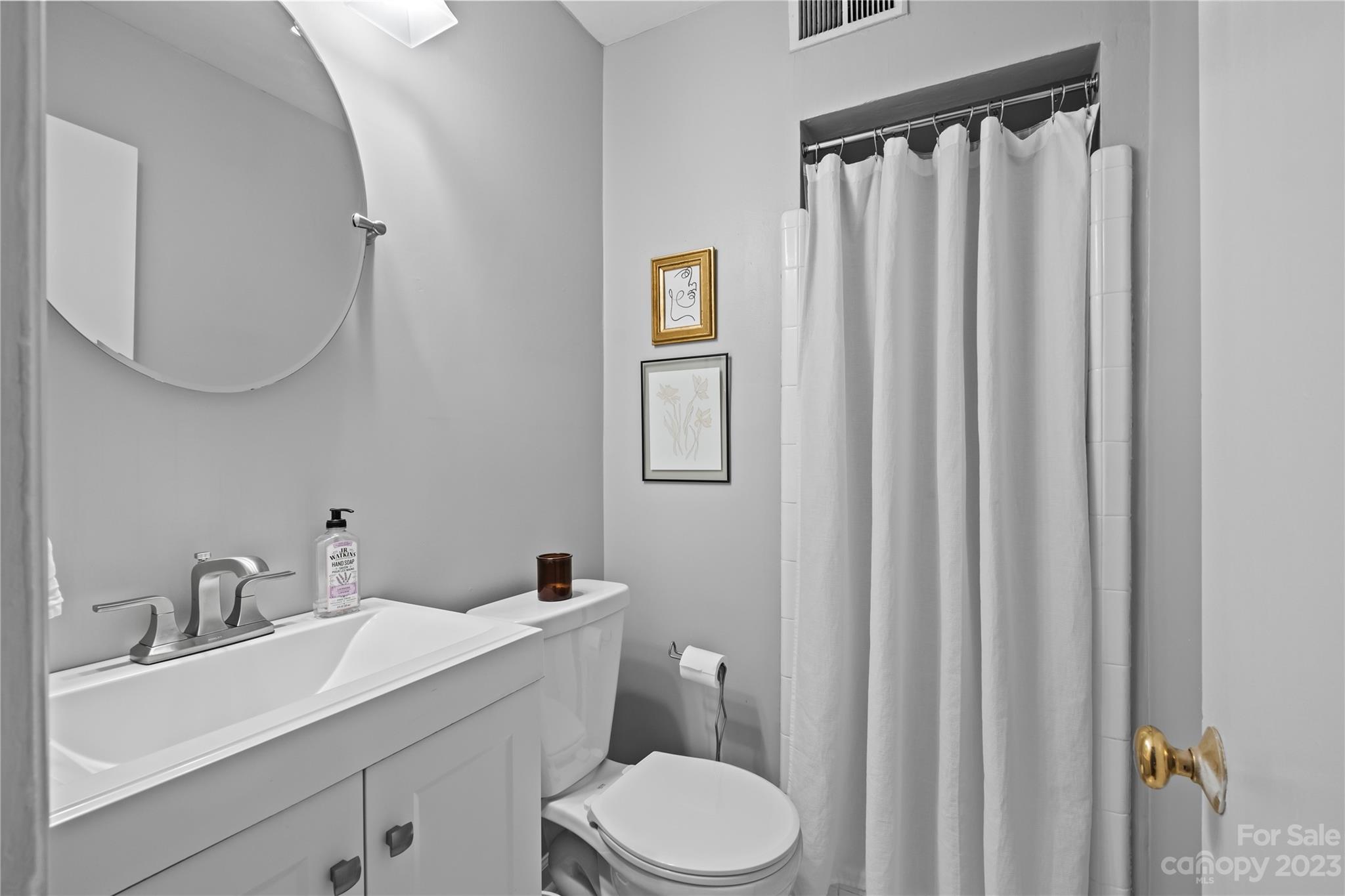4014 Sulkirk Road Charlotte, NC 28210 - Photo 19 of 23 a bathroom with a toilet a sink and mirror