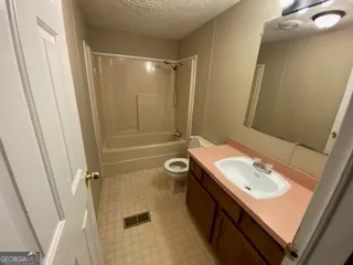 a bathroom with a sink a toilet a mirror and shower