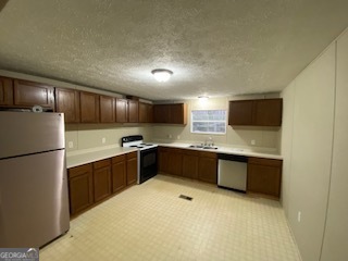 1368 Dee Kennedy Road Auburn, GA 30011 - Photo 4 of 15 a kitchen with stainless steel appliances granite countertop a refrigerator a sink dishwasher a stove top oven a sink and dishwasher