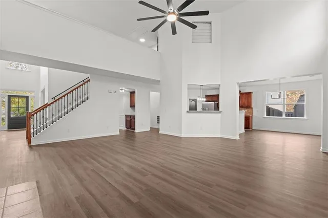 a view of a kitchen with a refrigerator a stove top oven a counter space and wooden floor