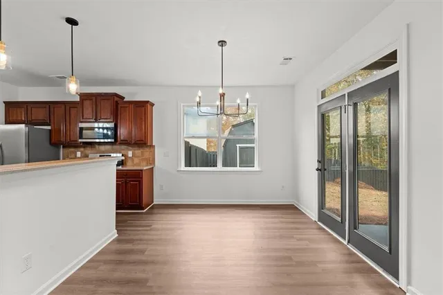 a kitchen with stainless steel appliances granite countertop a stove microwave refrigerator and sink