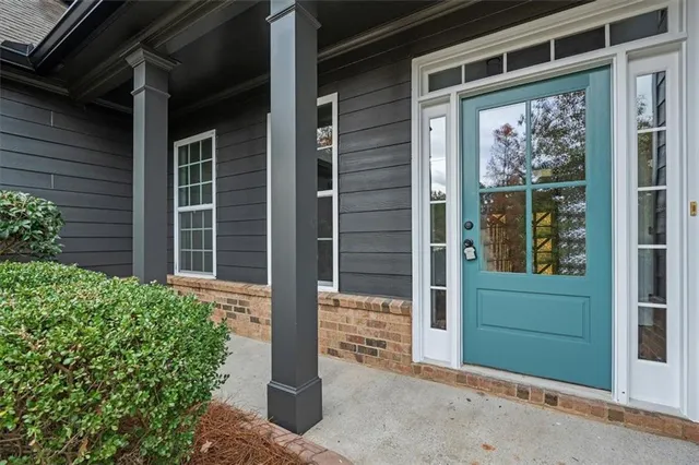 a view of an empty room with wooden floor and windows