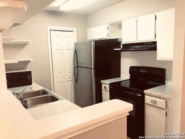 a kitchen with a refrigerator sink and stove