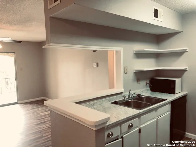 a kitchen with a sink cabinets and a wooden floor