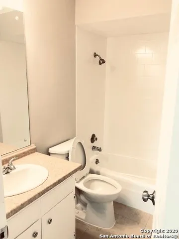 a bathroom with a granite countertop toilet a sink and a mirror