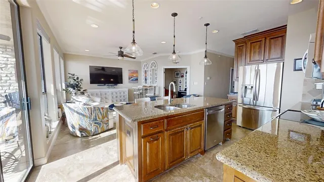 a kitchen with kitchen island granite countertop a sink stove and refrigerator
