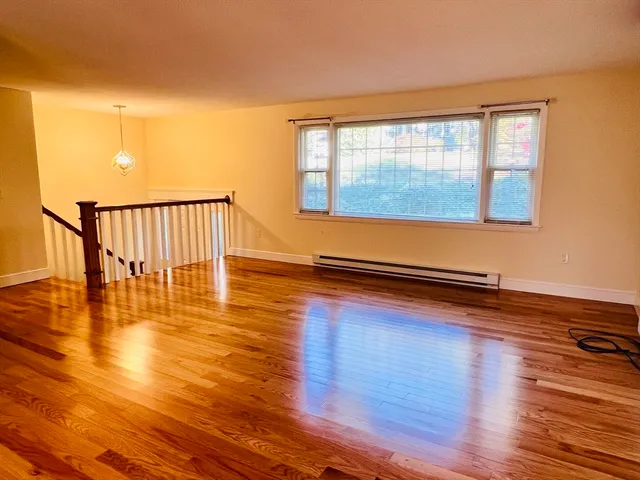 a view of a room with wooden floor and a window