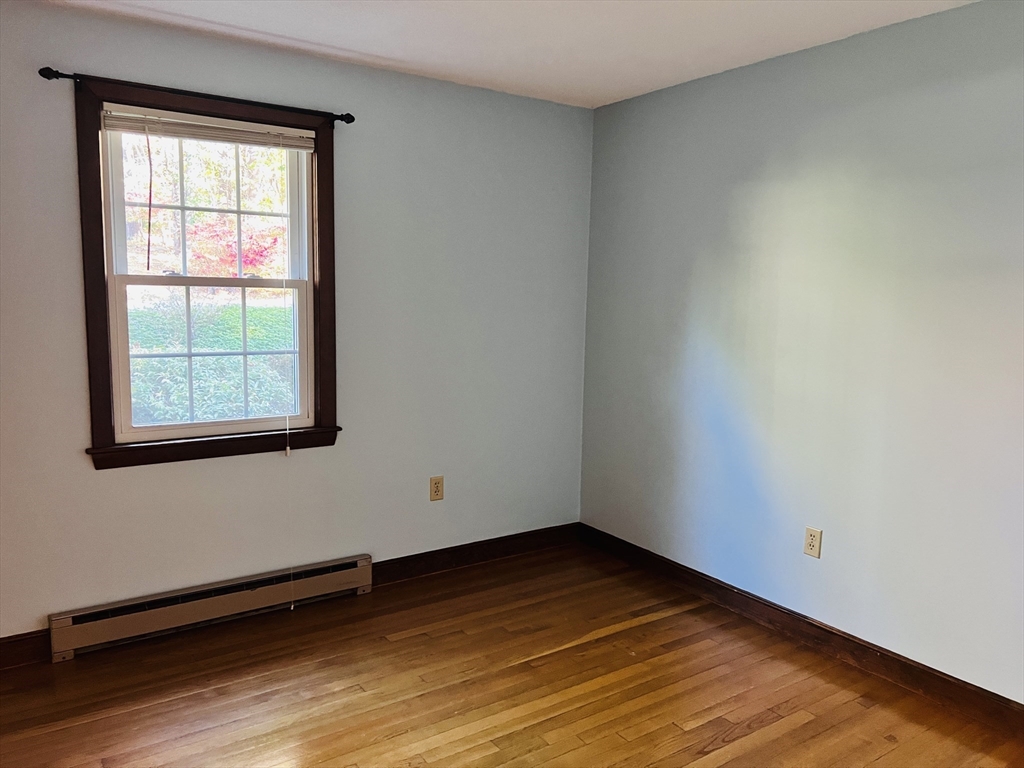 135 Walker Pond Road Sturbridge, MA 01566 - Photo 10 of 16 an empty room with wooden floor and windows