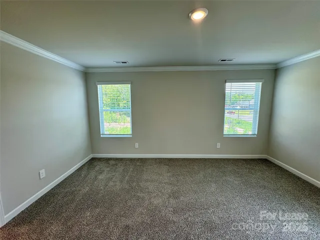 an empty room with closet and windows