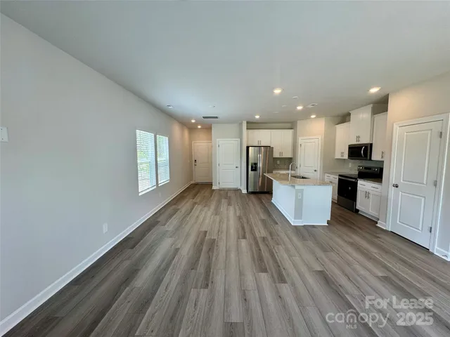 a view of kitchen with wooden floor and electronic appliances