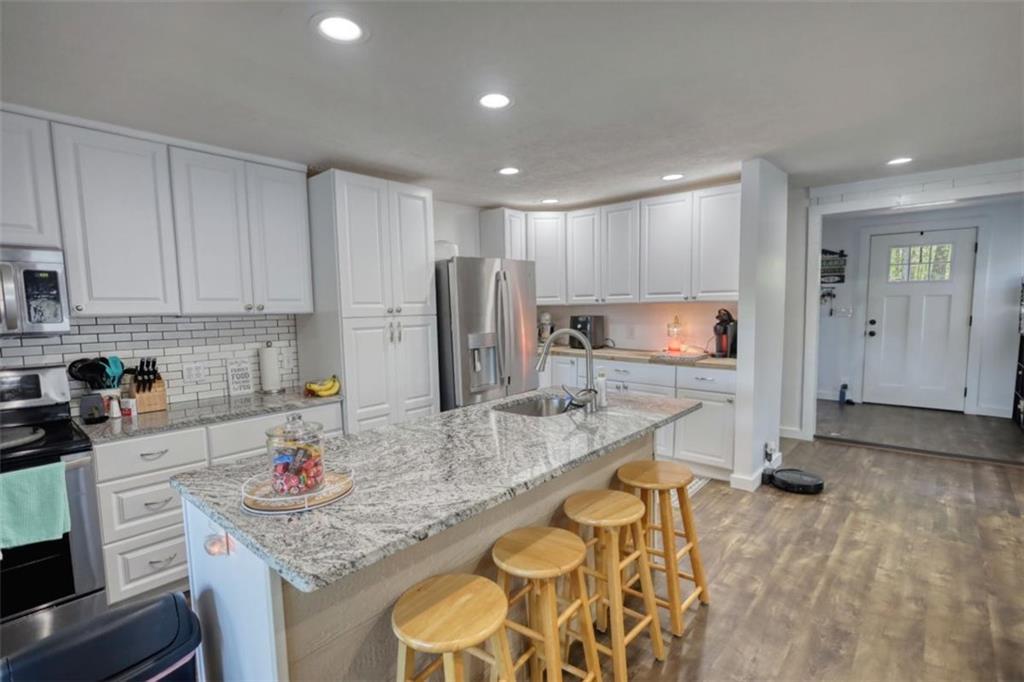 89 Miss Sarah Road Monticello, GA 31064 - Photo 24 of 77 a kitchen with stainless steel appliances granite countertop a sink refrigerator and cabinets