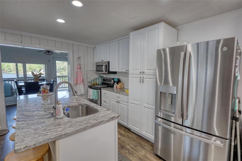 89 Miss Sarah Road Monticello, GA 31064 - Photo 27 of 77 a kitchen with kitchen island a counter top space cabinets and stainless steel appliances