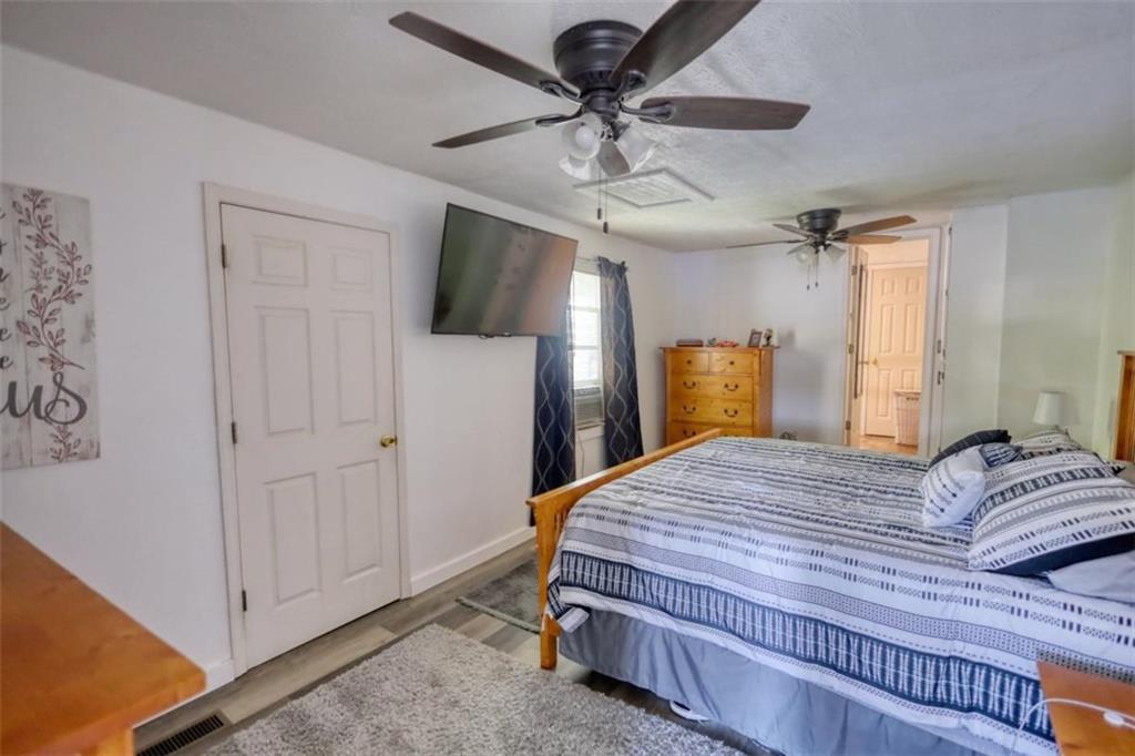 89 Miss Sarah Road Monticello, GA 31064 - Photo 35 of 77 a bedroom with a bed and a chandelier