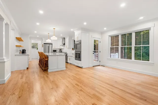 a view of kitchen with stainless steel appliances granite countertop a refrigerator and a stove top oven