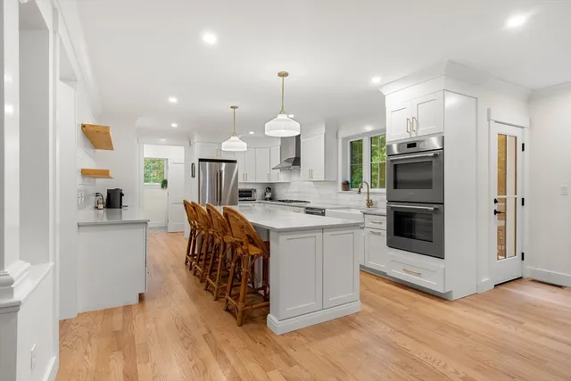 a large white kitchen with lots of counter space a sink and appliances
