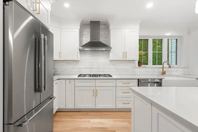 a kitchen with stainless steel appliances granite countertop a stove a sink and a refrigerator