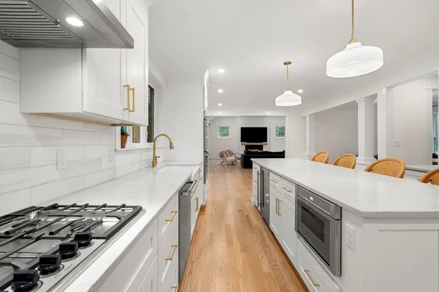 a large kitchen with stainless steel appliances granite countertop a lot of counter space and wooden floor