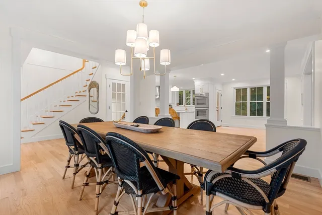 a view of a dining room and livingroom with furniture wooden floor a chandelier