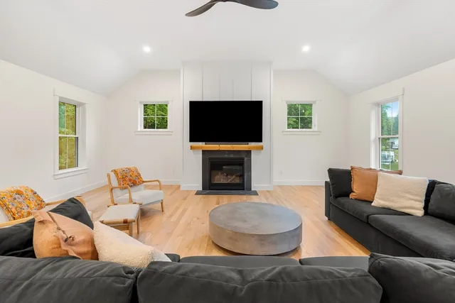 a living room with furniture a flat screen tv and a fireplace